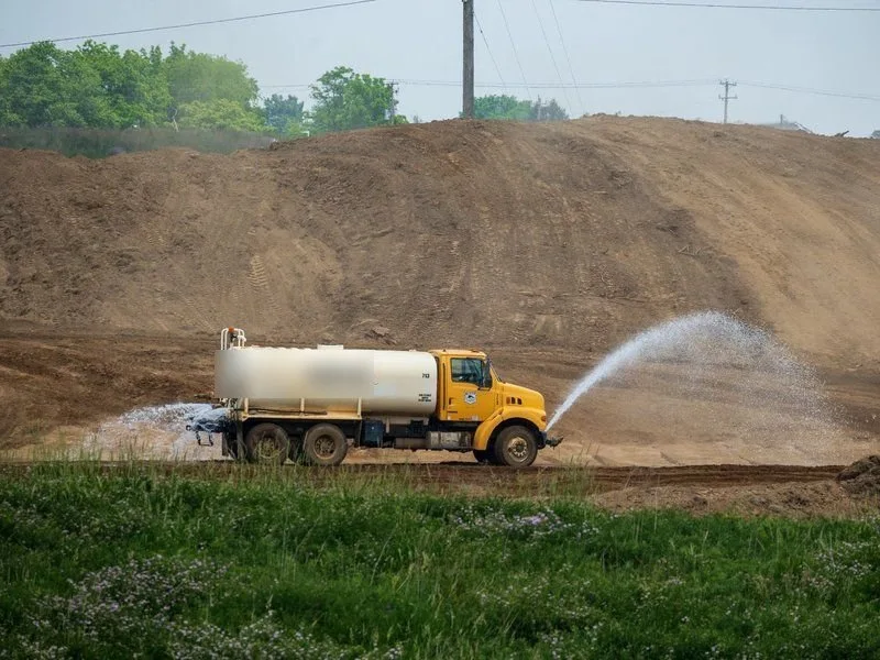 Stock photo of a water truck spraying a road